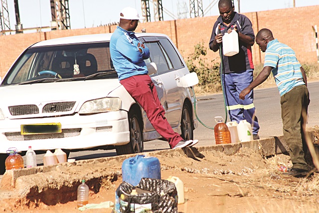 A motorist refuels at a dealer along Nketa Drive in Nketa in December 2017. Despite danger posed to property by keeping drums of fuels inside houses, some people continue doing so.