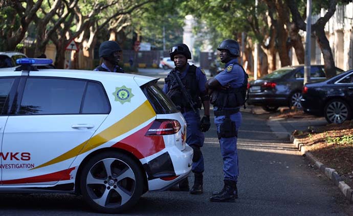 Hawks and members of the SAPS are seen outside the Gupta compound in Saxonwold , Johannesburg. Picture: ALON SKUY