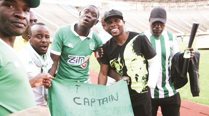 THROUGH THICK AND THIN . . . CAPS United captain Hardlife Zvirekwi (second from right), who lost his arm in a car accident in Harare, gets a “Get Well Soon” message from his side’s fans during Castle Lager Premiership soccer match against Harare City at the National Sports Stadium last month