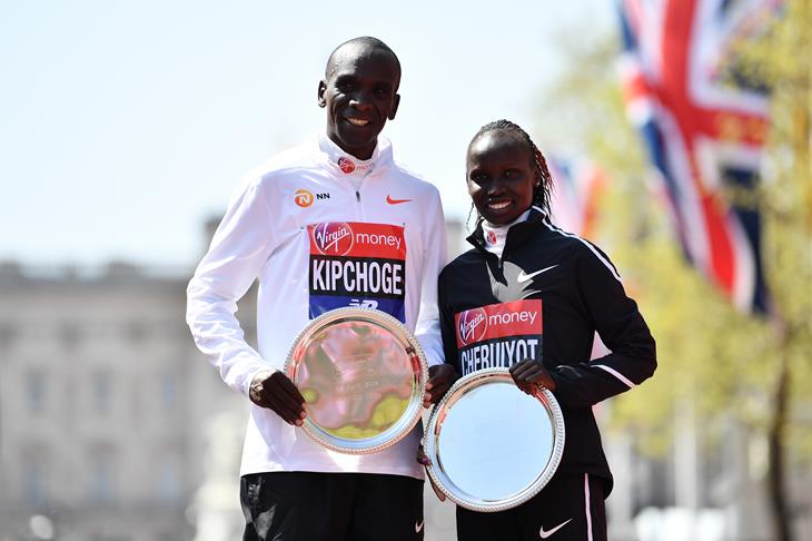 Eliud Kipchoge and Vivian Cheruiyot pose with their trophies, following their first-place results