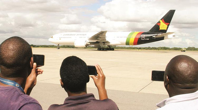 People photograph Air Zimbabwe’s newly-acquired Boeing 777-200ER at Robert Gabriel Mugabe International Airport in Harare yesterday. — ( Picture by Kudakwashe Hunda)