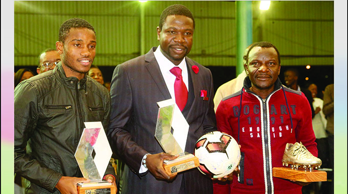THE JOY OF SUCCESS . . . Ovidy Karuru (left), the player who captained the Warriors to glory in the COSAFA Cup last year, joins team manager Wellington Mpandare (right) and national team benefactor Walter Magaya in displaying some of the medals they won during that adventure in South Africa