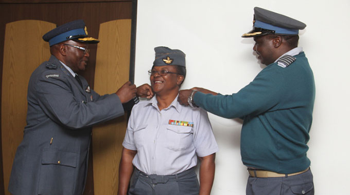 Air Vice Marshall Jacob John Nzvede (left) and Group captain Frank Tagarira adorn Squadron Leader Sipiwe Nyakabau with epaulettes for her new rank of Wing Commander at Josiah Magama Tongogara Barracks in Harare yesterday. — Picture by Innocent Makawa