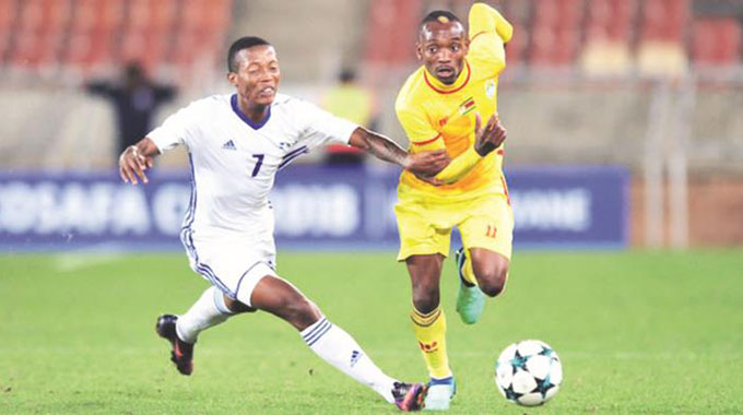 FOUL PLAY . . . A Lesotho defender resorts to using his hand to try and stop Warriors forward Khama Billiat from streaking clear during the COSAFA Cup semi-final at the new Peter Mokaba Stadium in Polokwane, South Africa, last night — Cosafa.com