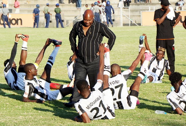 Highlanders coach Madinda Ndlovu chats with his players after a match against Chicken Inn FC