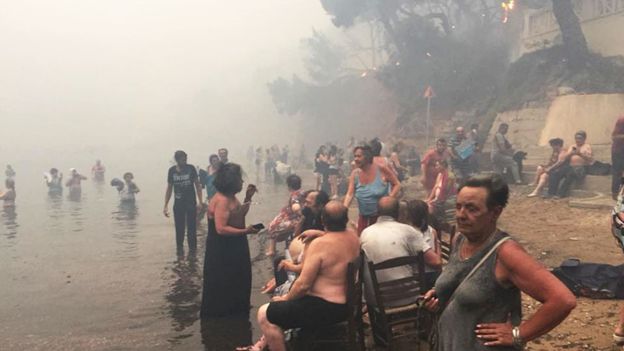 People attempt to escape the wildfires near the seaside village of Mati