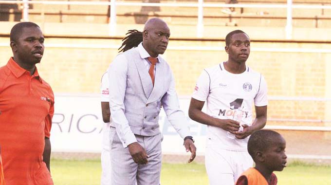 IT’S ALL GLOOMY . . . Dynamos coach Lloyd Mutasa and his son Panashe (right) start the long and lonely trip to the refuge of the dressing rooms after the Glamour Boys’ poor show against Chapungu in a Castle Lager Premiership match at Rufaro yesterday