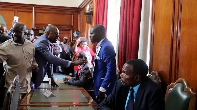 Councillor Arnold Batirai (right) being asked to calm down by Councillor Felix Mhaka during a confrontation with residents at the swearing in of councillors at the council chambers in Bulawayo on Friday