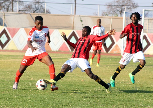 Bulawayo City defender Lewis Ncube(left) tries his way past Chicken Inn's Ishumael Lawe while Michael Bhebhe (right) monitors the action during a Heroes Day match at White City Stadium in Bulawayo