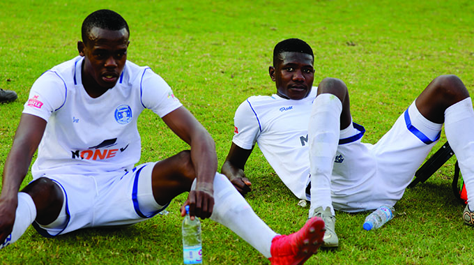 IT’S A TOUGH WORLD . . . Defeated and demoralized Dynamos players Blessing Moyo (left) and Tawanda Macheka reflect on their team’s latest depressing loss at the hands of Harare City at Rufaro on Sunday, a result which left the misfiring Glamour Boys in real danger of relegation