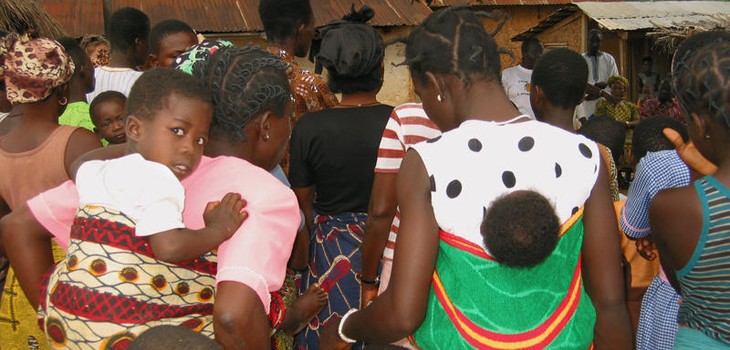 A crowd gathers for a community meeting about family planning in Ghana.