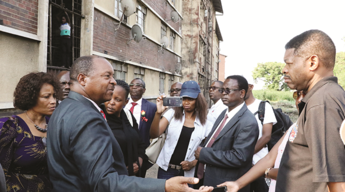 Minister of Health and Child Care Dr Obadiah Moyo (right) stresses a point to Bulawayo City Council director of Engineering Services Engineer Simela Dube while the Town Clerk Mr Christopher Dube (second right) looks on during a tour of Burombo Flats in Bulawayo on Friday. — Picture by Eliah Saushoma