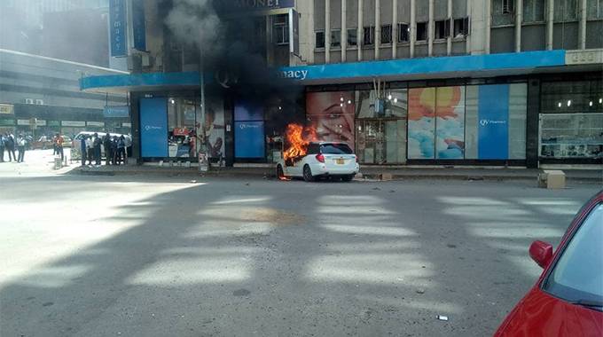The alleged shooter's car was set alight by an angry mob.