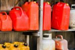 Keeping fuel in homes illegal, says Police, Ema A group of jerry cans and propane tanks sit on shelves in a wooden shed.