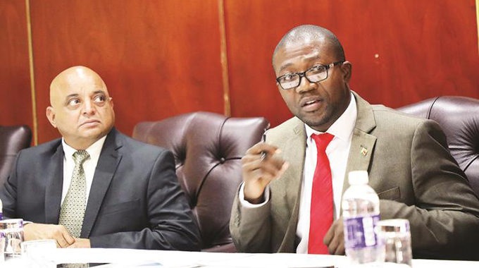 Industry and Commerce Minister Mangaliso Ndlovu and his deputy Raj Modi follow proceedings during a meeting with manufacturers and retailers on price hikes in Harare yesterday. — Picture by Memory Mangombe