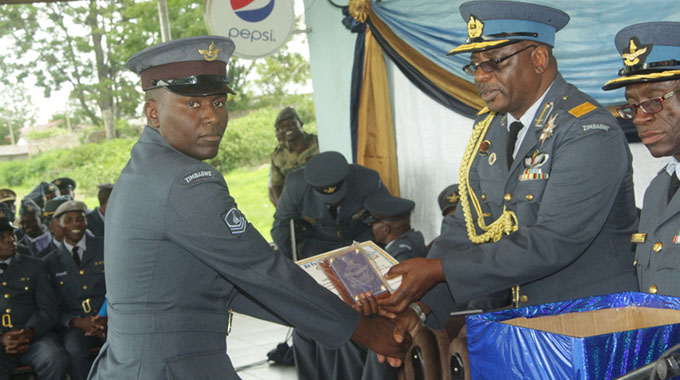 Director (Training and Operations) Air Commodore Elisha Masakadza hands over a certificate to overall best student Master Sergeant Edmore Majoni at a graduation ceremony for senior non-commissioned officers at Manyame Airbase yesterday. — Picture by Nyasha Chawatama.