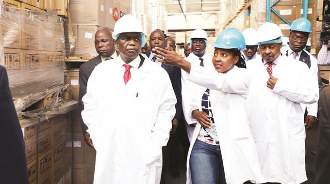 Acting President Constantino Chiwenga and Health and Child Care Minister Obadiah Moyo (right) are led on a tour of NatPharm Warehouse in Harare yesterday by Natpharm Stores Pharmacist Rumbidzai Matambanadzo. — (Picture by Justin Mutenda)