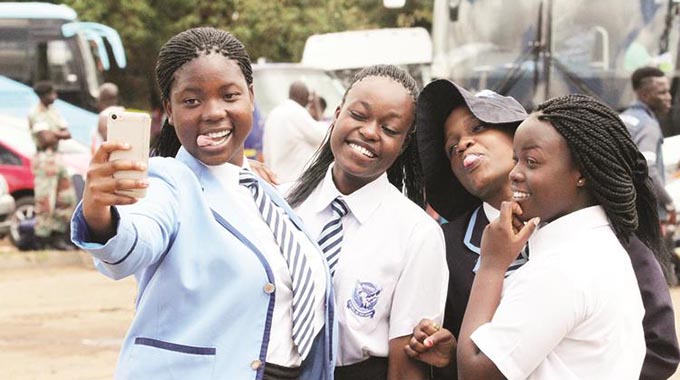 Howard High School students take selfies before leaving Harare ahead of the opening of the first term of schooling at Rotten Row Bus Terminus yesterday. — (Picture by Innocent Makawa)
