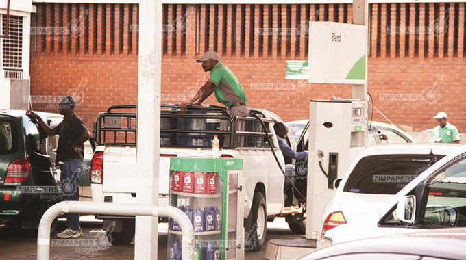 A fuel attendant fills drums at a service station in Belvedere. There have been cases of fuel being diverted to the black market. — (Picture by Shelton Muchena)