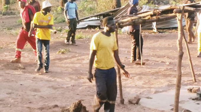Artisanal miners walk away from the collapsing Wonderer Mine in Shurugwi on Saturday