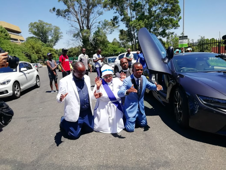 Incredible Happenings Ministries leader Paseka 'Mboro' Motsoeneng prays next to his BMW i8 before he goes to the Sandton police station to lay a charge against pastor Alph Lukau, of Alleluia Ministries on Thursday February 28 2019. (Image: Nomahlubi Jordaan)