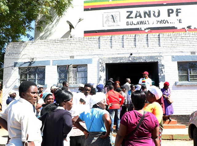 Zanu-PF party supporters queue to cast their votes at the party Davies Hall polling station in Bulawayo