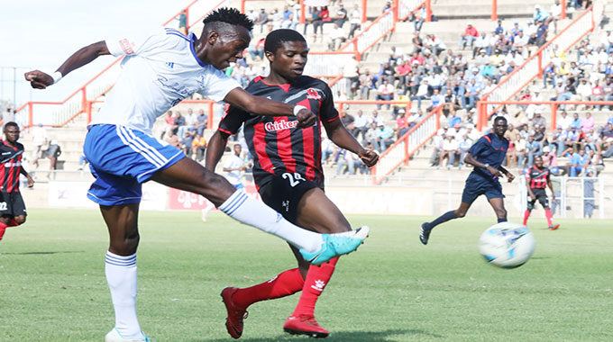 Dynamos FC player Selemani Jarrison shoots at goal under close watch of his opposite number Xolani Ndlovu of Chicken Inn FC in a match played at Barbourfields Stadium in Bulawayo.