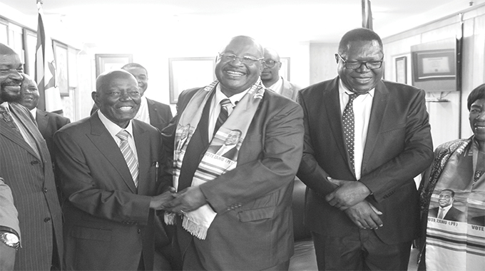 Secretary for Administration Obert Mpofu shakes hands with Didymus Mutasa while Ambrose Mutinhiri and Simbarashe Mumbengegwi (left) look on at the party Headquarters in Harare yesterday. Picture by Innocent Makawa