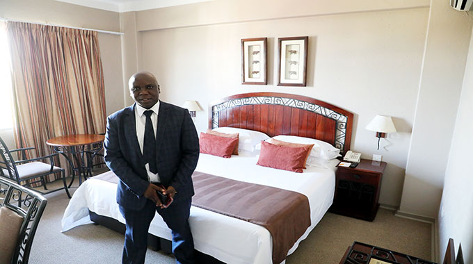 Bulawayo Rainbow Hotel General Manager, Mr Innocent Kufa, shows one of the refurbished rooms to journalists during a tour of the hotel on Wednesday