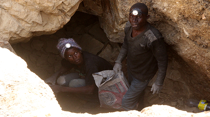 Some of the illegal miners search for their colleagues who are believed to be trapped underground after a shaft collapse at Nugget Mine in Matobo