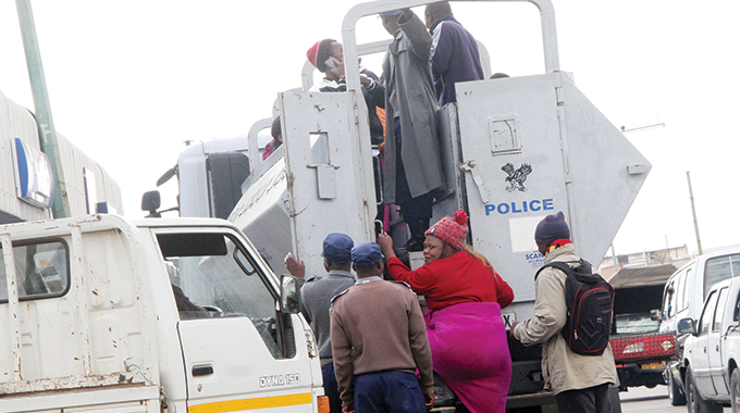 Illegal forex dealers, popularly known as Osiphatheleni, being rounded up by police near Tredgold building in Bulawayo on Friday. The picture shows one of the suspected money changers getting on board a police vehicle. — (Picture by Nkosizile Ndlovu)