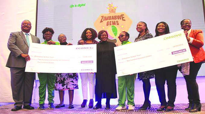 Econet Wireless chief operating officer Fayaz King (far left) and Cassava Smartech chief executive officer-on-demand services Dorothy Zimuto (far right) present two cheques to senior netball team representatives led by Zimbabwe Netball Association president Leticia Chipandu (centre) at the handover ceremony in Harare yesterday
