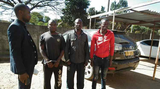 A police detective (left) with three of the suspects at Chipinge Police Station.