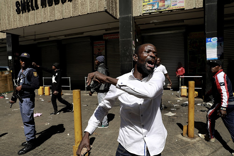 A foreign national reacts in the Johannesburg CBD after a foreign-owned shop was looted. Image: Alon Skuy