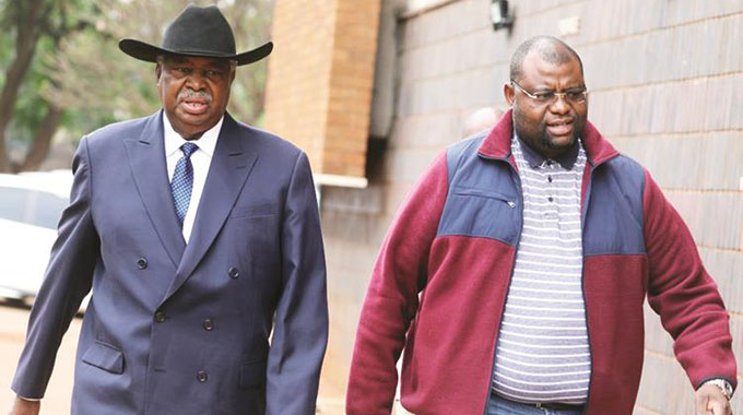 Former Vice President Phelekezela Mphoko and his son walking into the Harare Magistrates Courts yesterday. — Picture: Lee Maidza