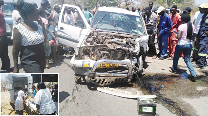 Two twin cabs were involved in a head on collision at Mkhosana turn-off soon after a prayer session to cleanse the spot on Saturday. (Inset) An injured driver is carried into an ambulance following the accident.