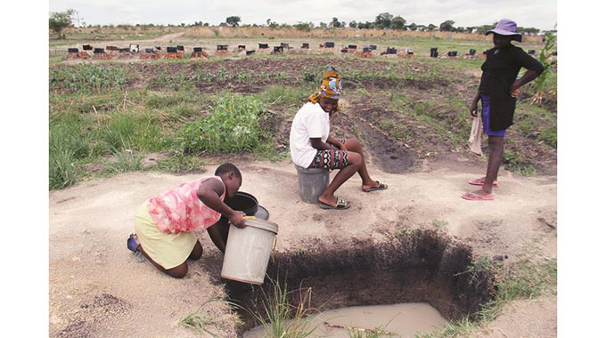Hopley residents draw water for domestic use from a well situated near Granville Cemetery in Harare South on Monday. — Picture: Innocent Makawa