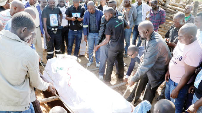 Pallbearers lower a casket with the body of Bheki Ndlovu at his rural home in Pumula Ward 18, Tsholotsho