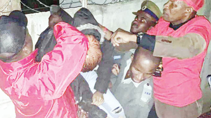 Police and concert security details attend to the semi-conscious woman yesterday morning