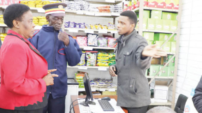Bulawayo Provincial Affairs Minister Cde Judith Ncube (left) asks the purported manager of Galaxy Cash and Carry Supermarket along Fort Street, Mr Shepherd Tsikira, on why his shop was demanding that clients who want to buy mealie-meal should first buy groceries of $150 yesterday