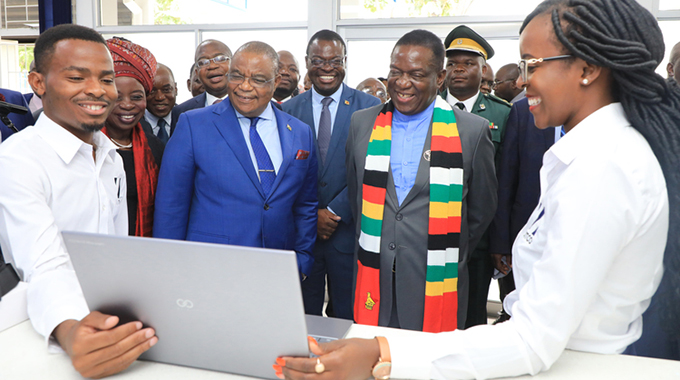 President Emmerson Mnangagwa being shown one of the laptops assembled at Zimbabwe Information Technology Company (ZITCO) by Chidochemoyo Chingwaru and Honest Mazura (left) in Msasa, Harare, yesterday. With him is Vice President Constantino Chiwenga and some Government ministers