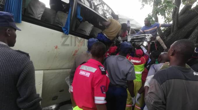 Firefighters and police officers rescue trapped passengers from the Zupco bus and one of the two kombis