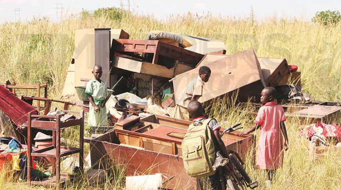 Hapless children gather their parents’ belongings after they were evicted at Water Vlei Farm in Chitungwiza yesterday. — Picture: Innocent Makawa