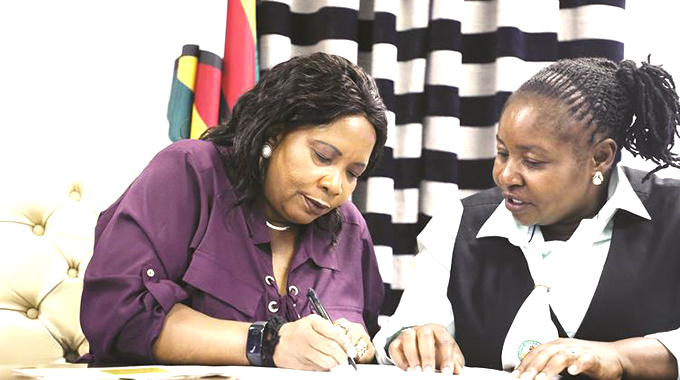 First Lady Auxillia Mnangagwa writes her defensive driving test under the watchful eye of Traffic Safety Council of Zimbabwe safety officer Ms Tsungai Mukwaiwa in Harare