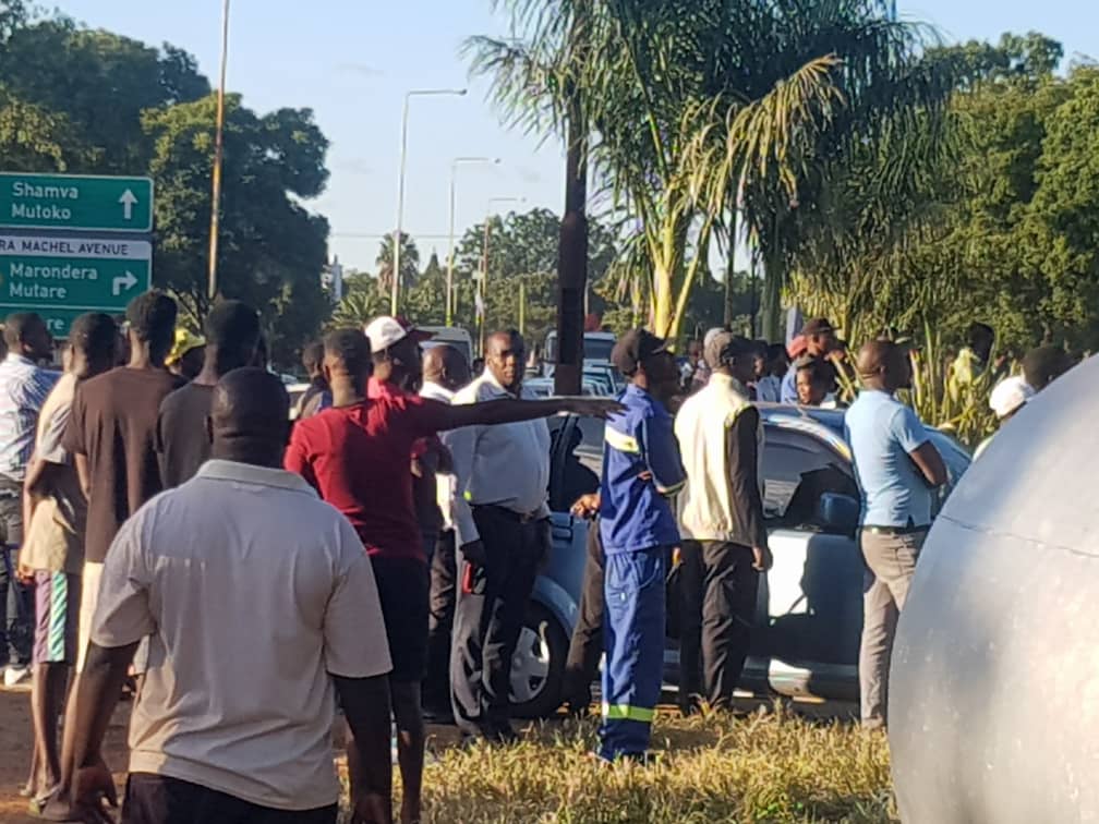 File picture of people milling around a scene where armed robbers had been shot by police in Harare (March 2020)
