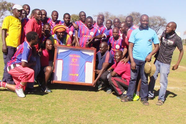 Former Masvingo United players pose with a framed Barcelona jersey which was given to the club’s former benefactor Tanda Tavaruva (Picture by The Standard)