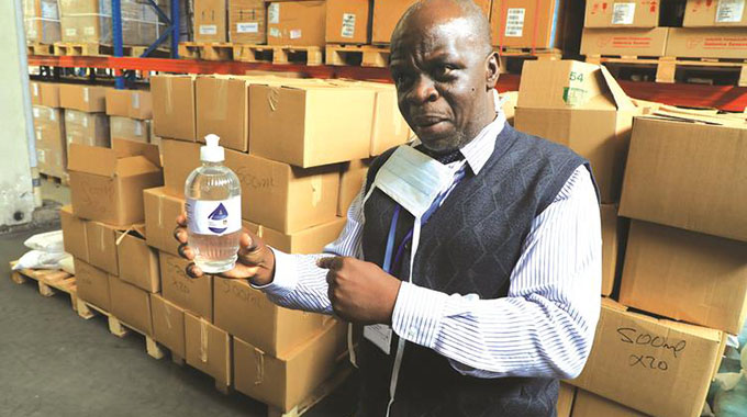 NatPharm acting operations director Mr Zealous Nyabadza shows a sample of sanitisers being produced at the University of Zimbabwe in Harare yesterday. — Picture: Tawanda Mudimu