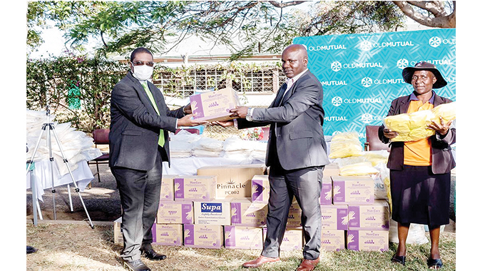 Old Mutual director and board member, Mr Todd Moyo (left) hands over Personal Protective Equipment to Byo Mayor Councillor Solomon Mguni on Tuesday