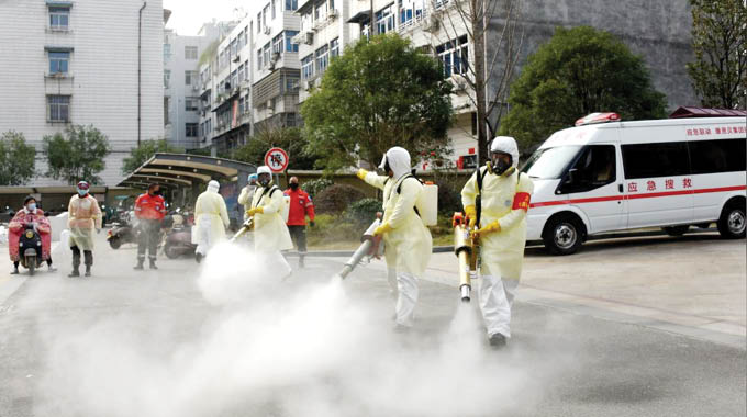 Volunteers in protective suits disinfect a residential compound, as the country is hit by the outbreak of a new coronavirus, in Taizhou, Zhejiang province, China