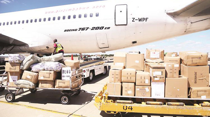 National Handling Services staff offload a 30-tonne consignment of Covid-19 materials from an Air Zimbabwe charter flight from China at Robert Gabriel Mugabe International Airport in Harare yesterday. Picture: Believe Nyakudjara
